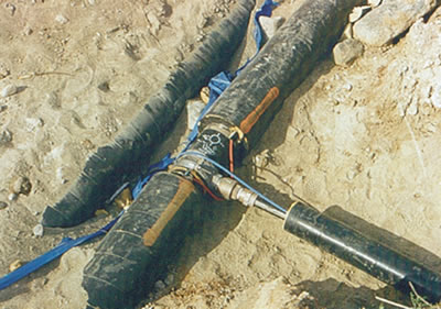 Raccordement de tuyau de branchement caractéristique, de
50 mm (2 po.), à une école de la Bearskin Lake Nation, au Nord de l'Ontario. Noter la couleur bleue du
THERMOCÂBLE® sur le branchement et rouge sur le collecteur principal. La plupart des THERMOCÂBLES® sont dotés de codes couleurs, afin d'identifier la densité de puissance et la tension: les tuyaux de branchements de petit diamètre exigent des puissances plus faibles que les collecteurs principaux. Une trousse d'isolation de selle de raccordement/robinet de prise en charge va ensuite être posée pour terminer l'installation.
